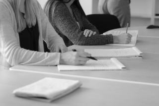 Stagiaires qui prennent des notes pendant une formation, en noir et blanc